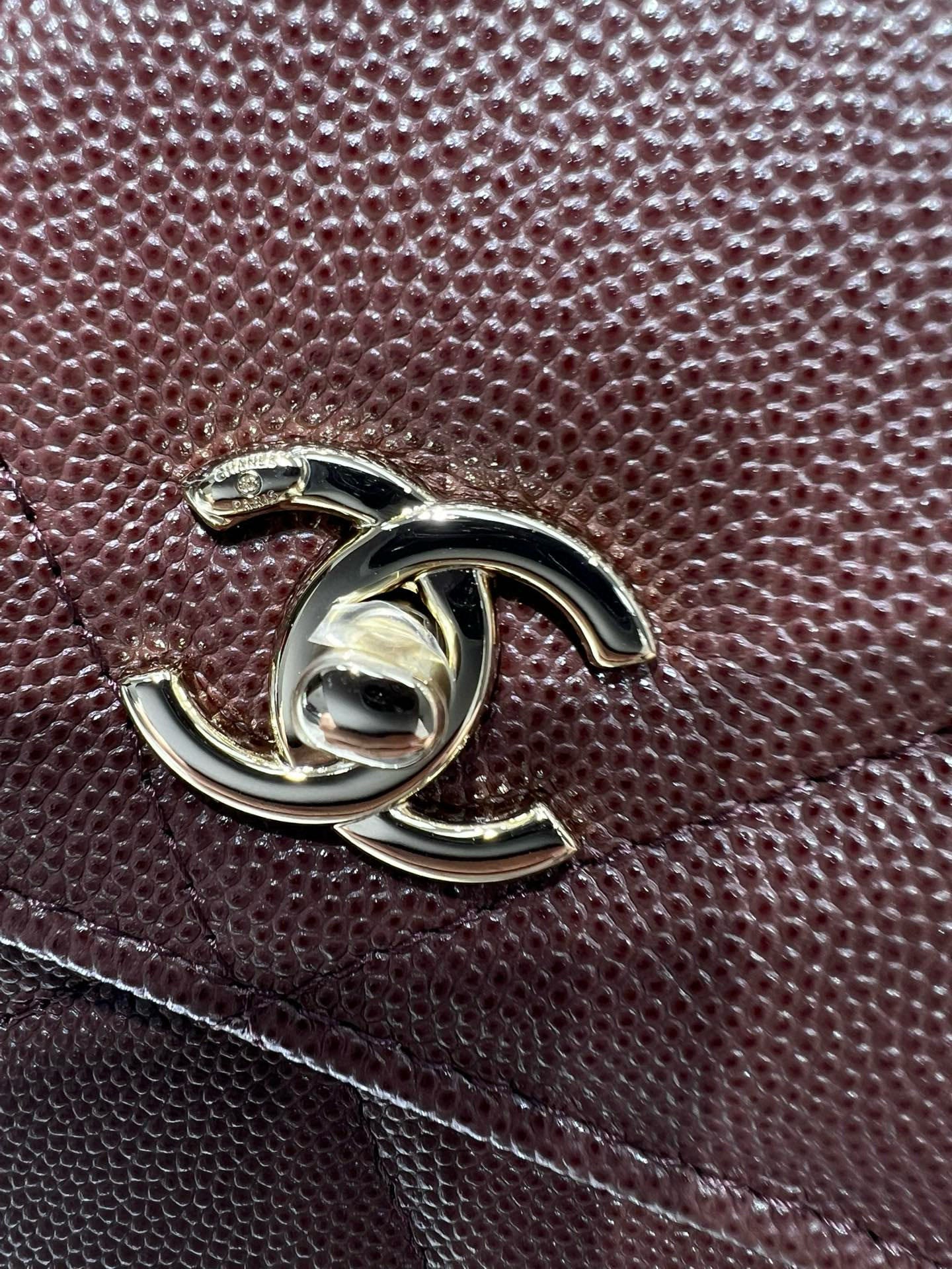 CC logo metal hardware on burgundy textured leather bag