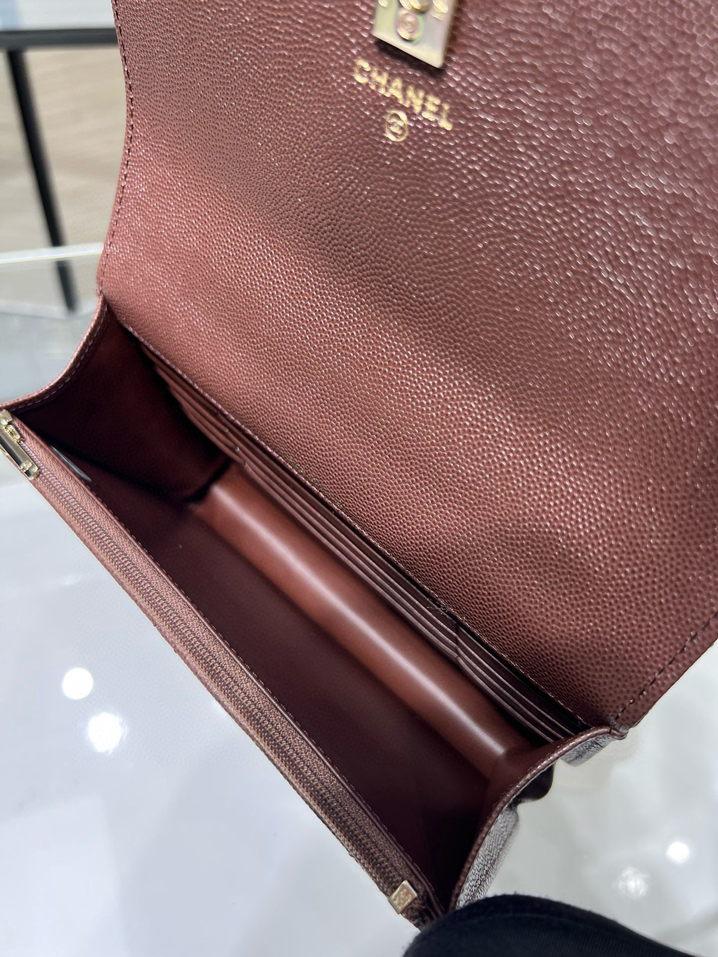 Small leather bag with open flap, burgundy exterior and brown interior