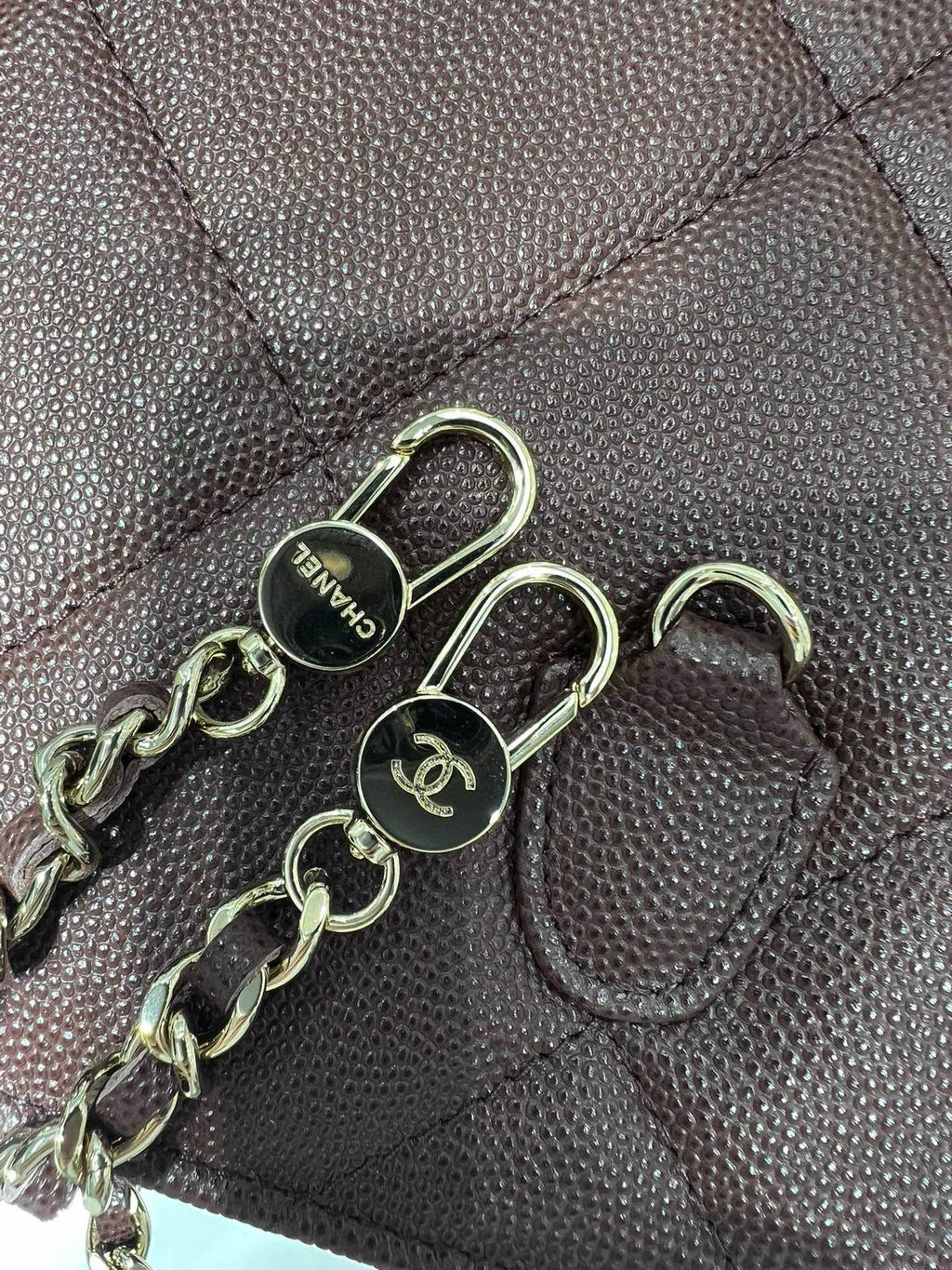 Metal chain and clasp on quilted leather bag, dark hardware
