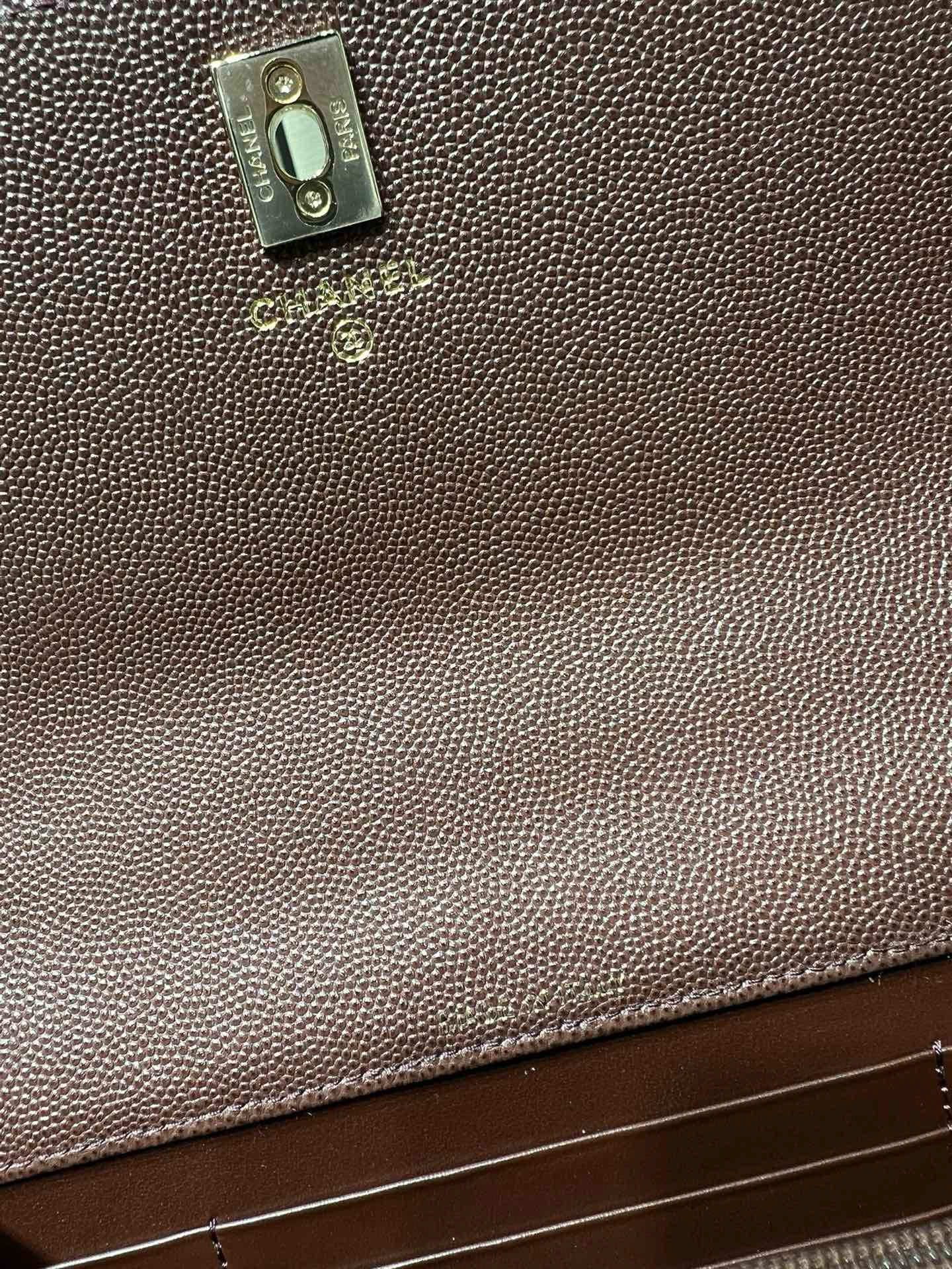 Branded metal tab on textured leather bag, taupe tone