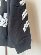 Black hoodie lower sleeve with Cabin Baggage graphic print and ribbed cuff