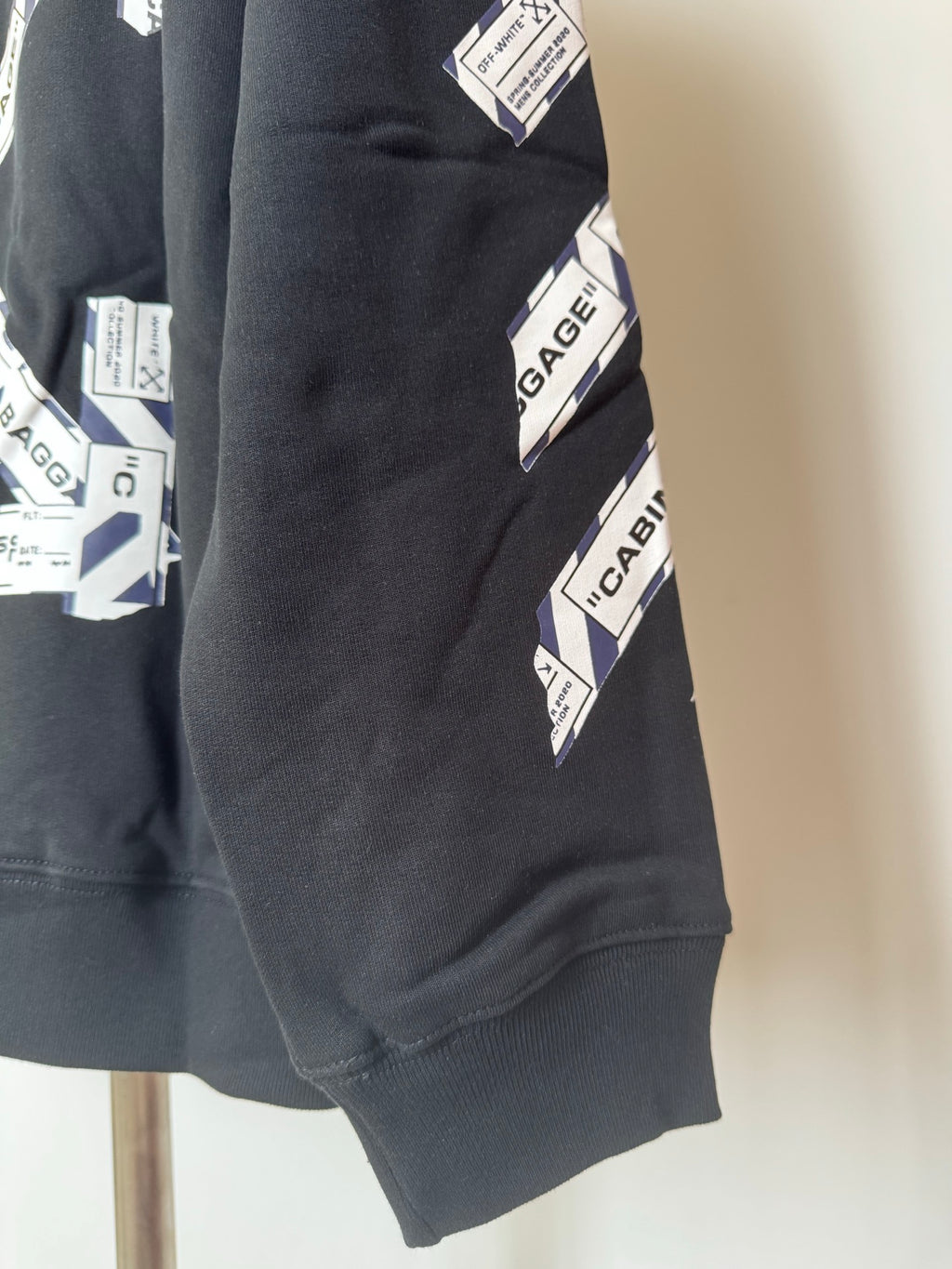 Dark hoodie sleeve with allover Baggage graphic and ribbed cuff