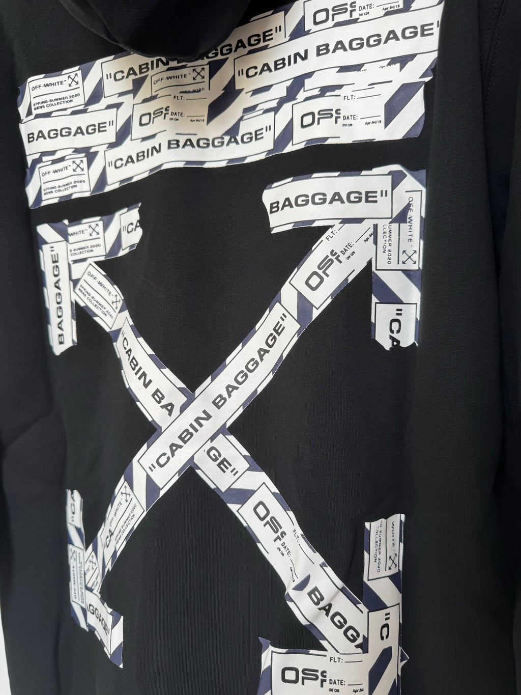 Black hoodie chest with Cabin Baggage logo X pattern and white label prints