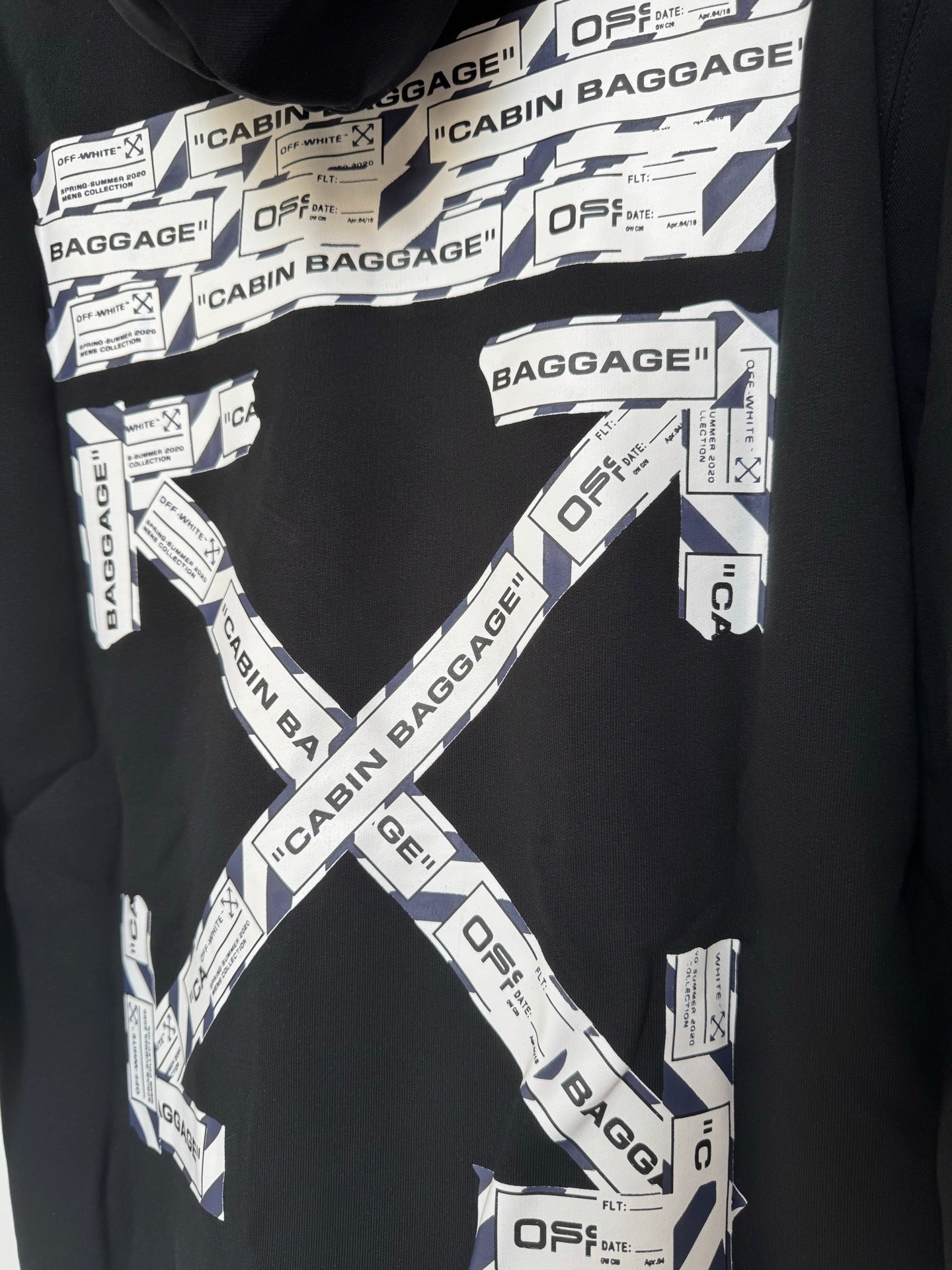 Black hoodie chest with Cabin Baggage logo X pattern and white label prints