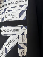 Black hoodie sleeve with Cabin Baggage label graphics and printed text