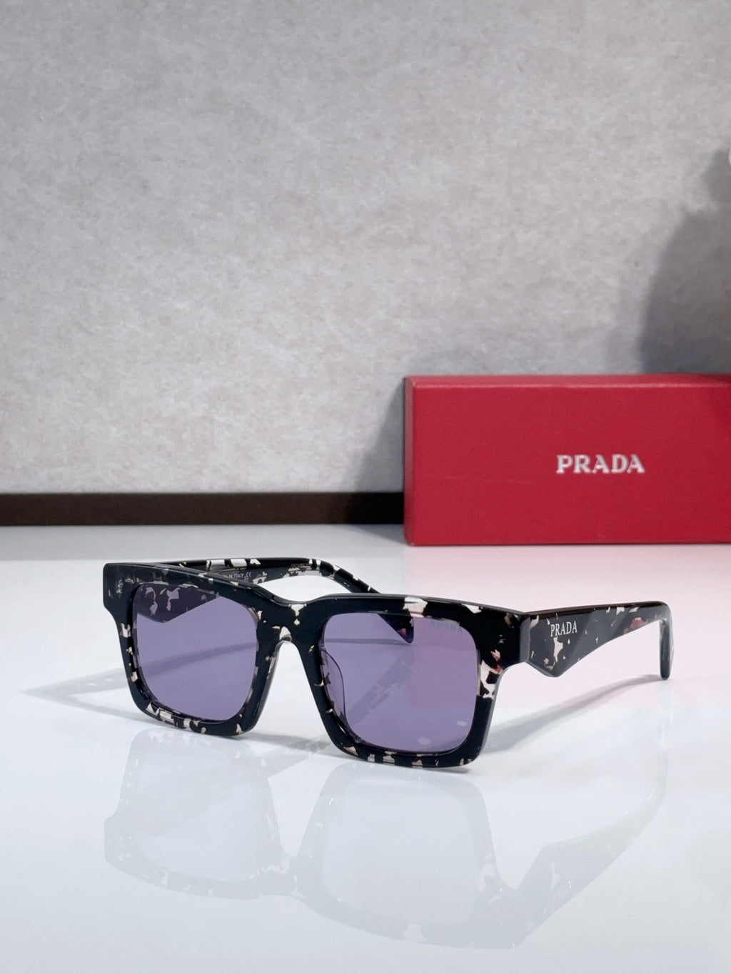 Prada square sunglasses with black frame and purple-tinted lenses