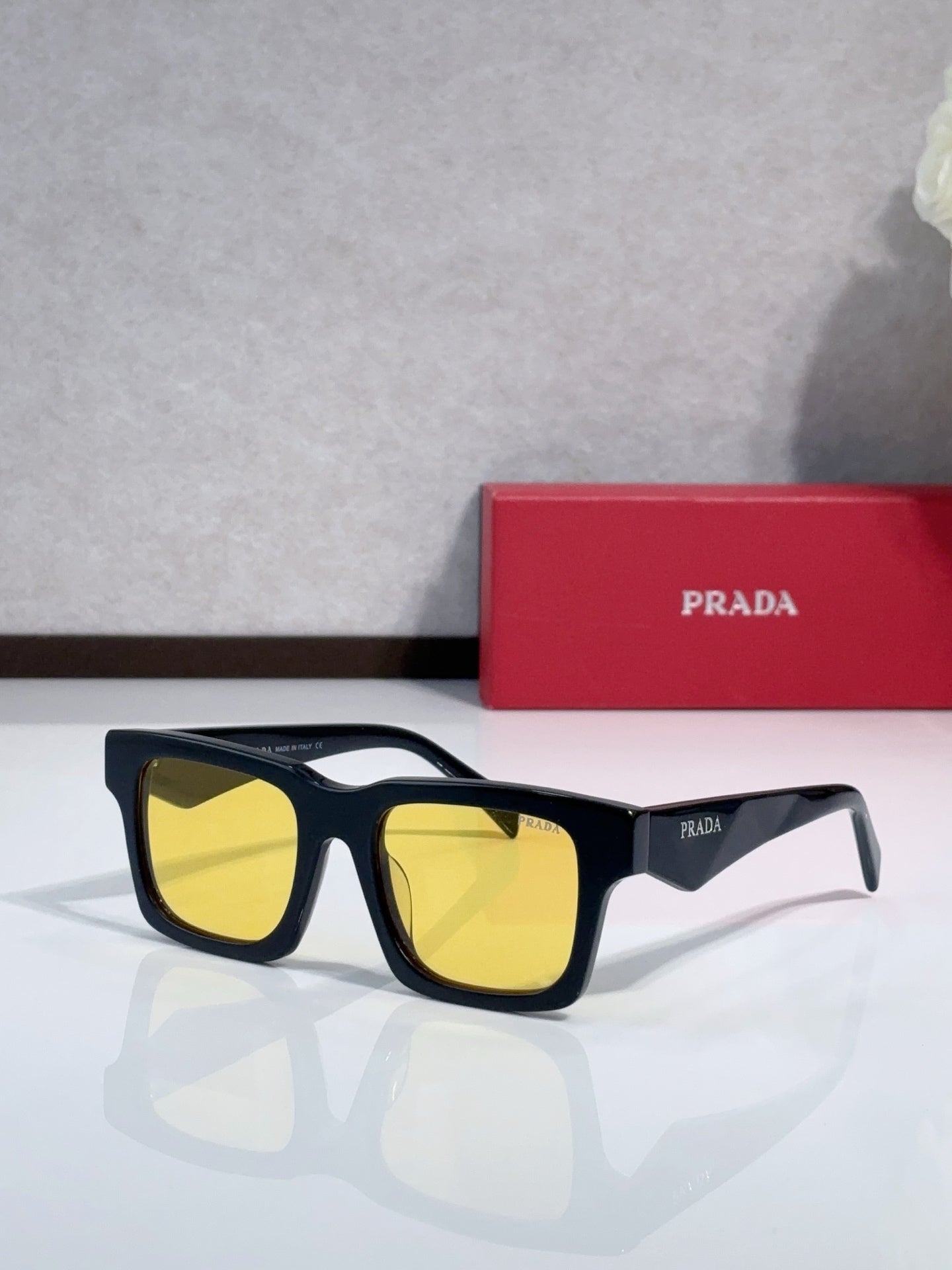 Prada square sunglasses with dark blue frame and yellow-tinted lenses