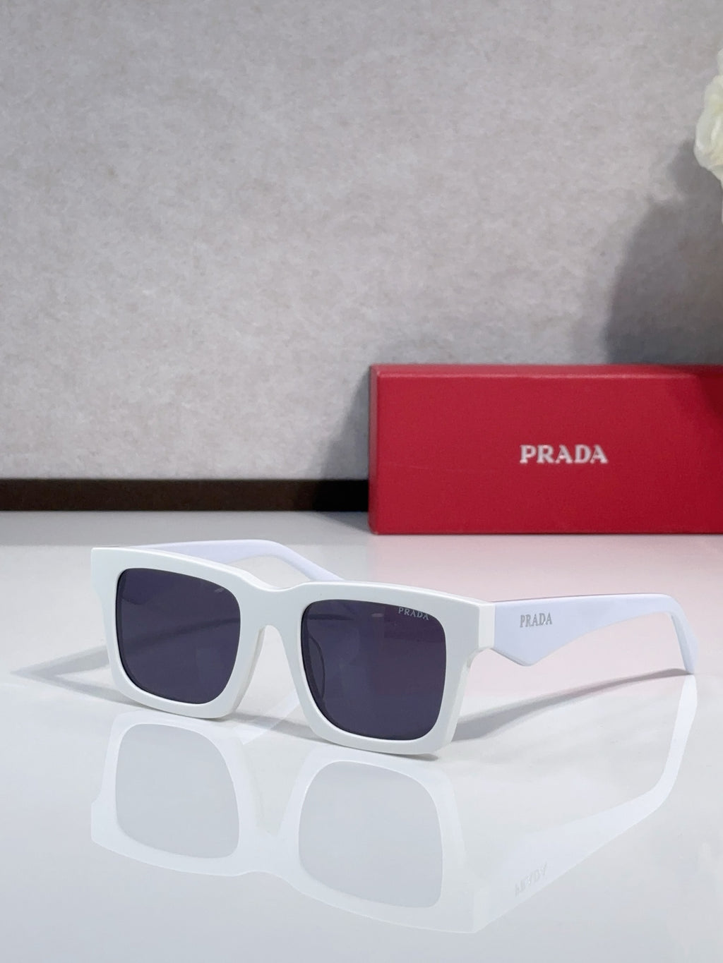 Prada square sunglasses with white frame and dark purple-tinted lenses