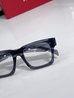 Eyeglasses close-up: dark blue square frames with clear lenses.