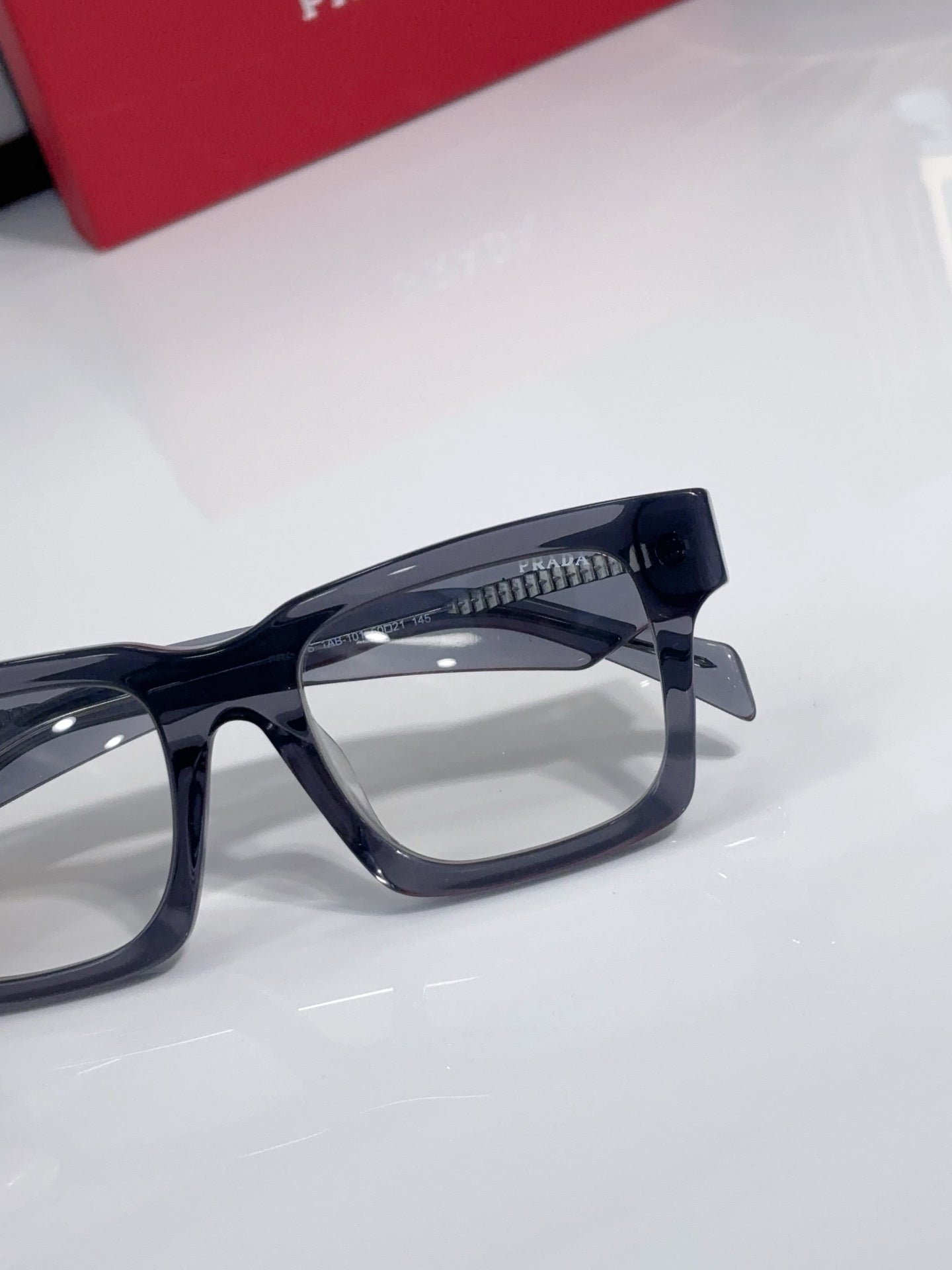 Eyeglasses close-up: dark blue square frames with clear lenses.