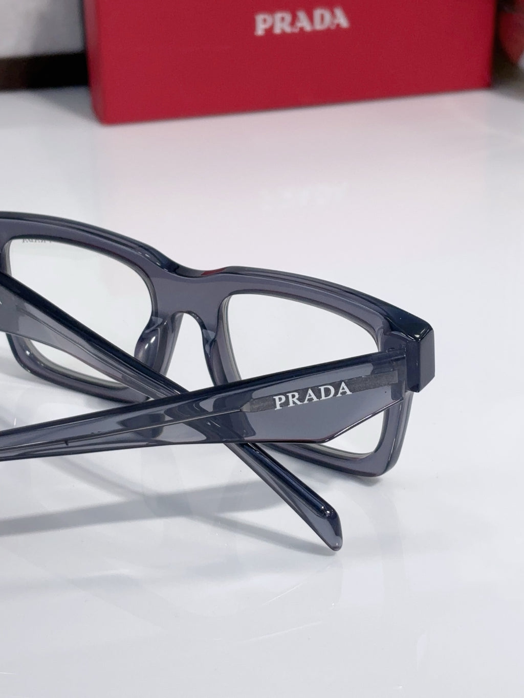 Eyeglasses side view close-up with dark blue rectangular frames and logo temple.