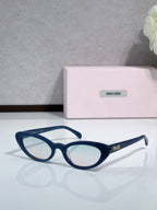 Cat-eye sunglasses with blue frames and clear lenses; logo on temple.