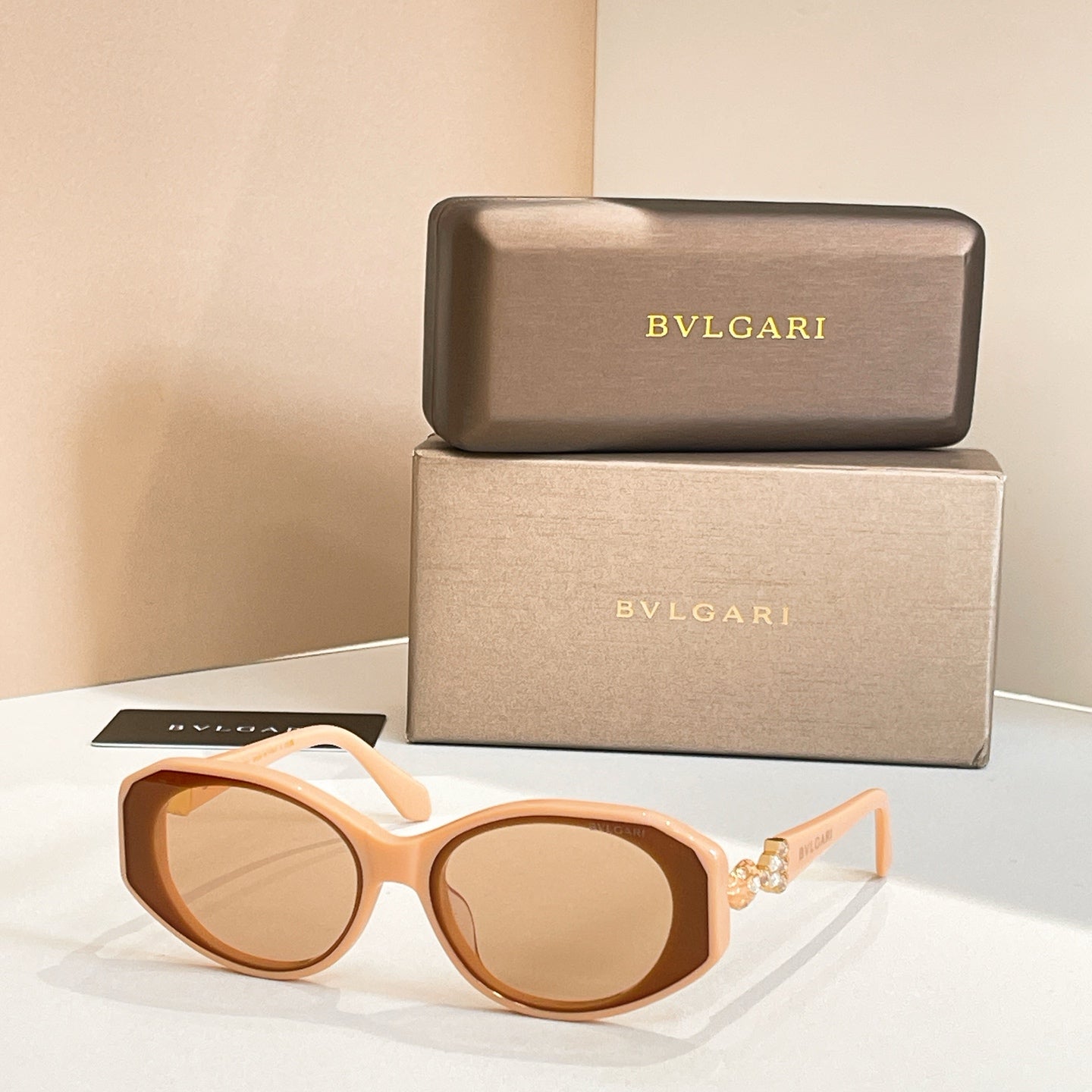 Light tan sunglasses with amber-tinted lenses and embellished temple detail