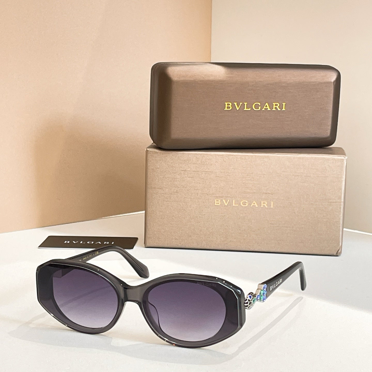 Black sunglasses with purple-tinted lenses and embellished temple detail