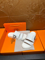 Hermes white slide sandals with two adjustable buckle straps, on pouch