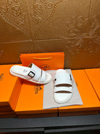 Hermes white slide sandals with two buckle straps, front open-toe view
