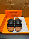 Hermes leather slide sandals with black straps and adjustable buckle, cushioned sole