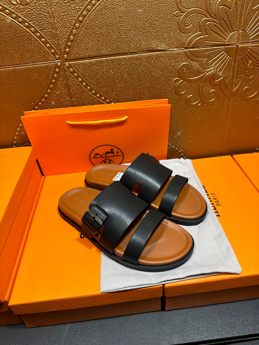 Hermes leather slide sandals, black upper with buckle detail and tan footbed