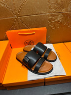 Hermes leather slide sandals, black upper with buckle detail and tan footbed