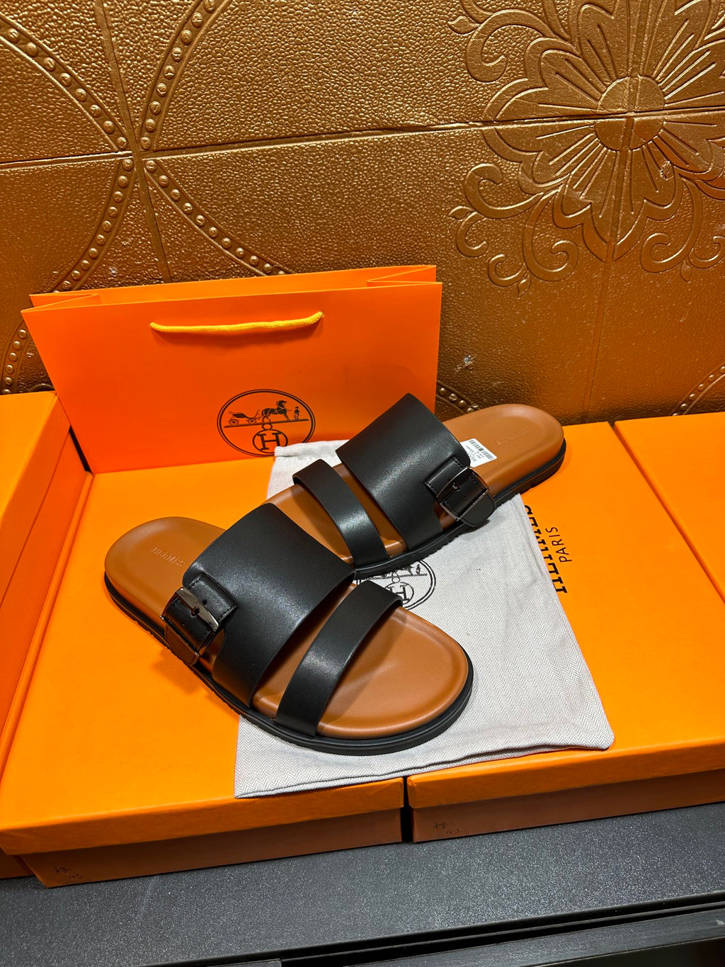 Hermes leather sandals with black dual straps and buckle closure, open toe view