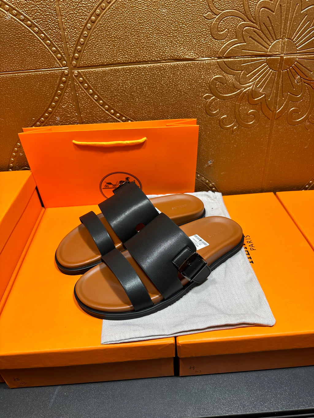 Hermes leather slide sandals in black with wide straps and single buckle strap