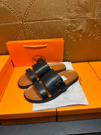 Hermes leather slide sandals in black with wide straps and single buckle strap