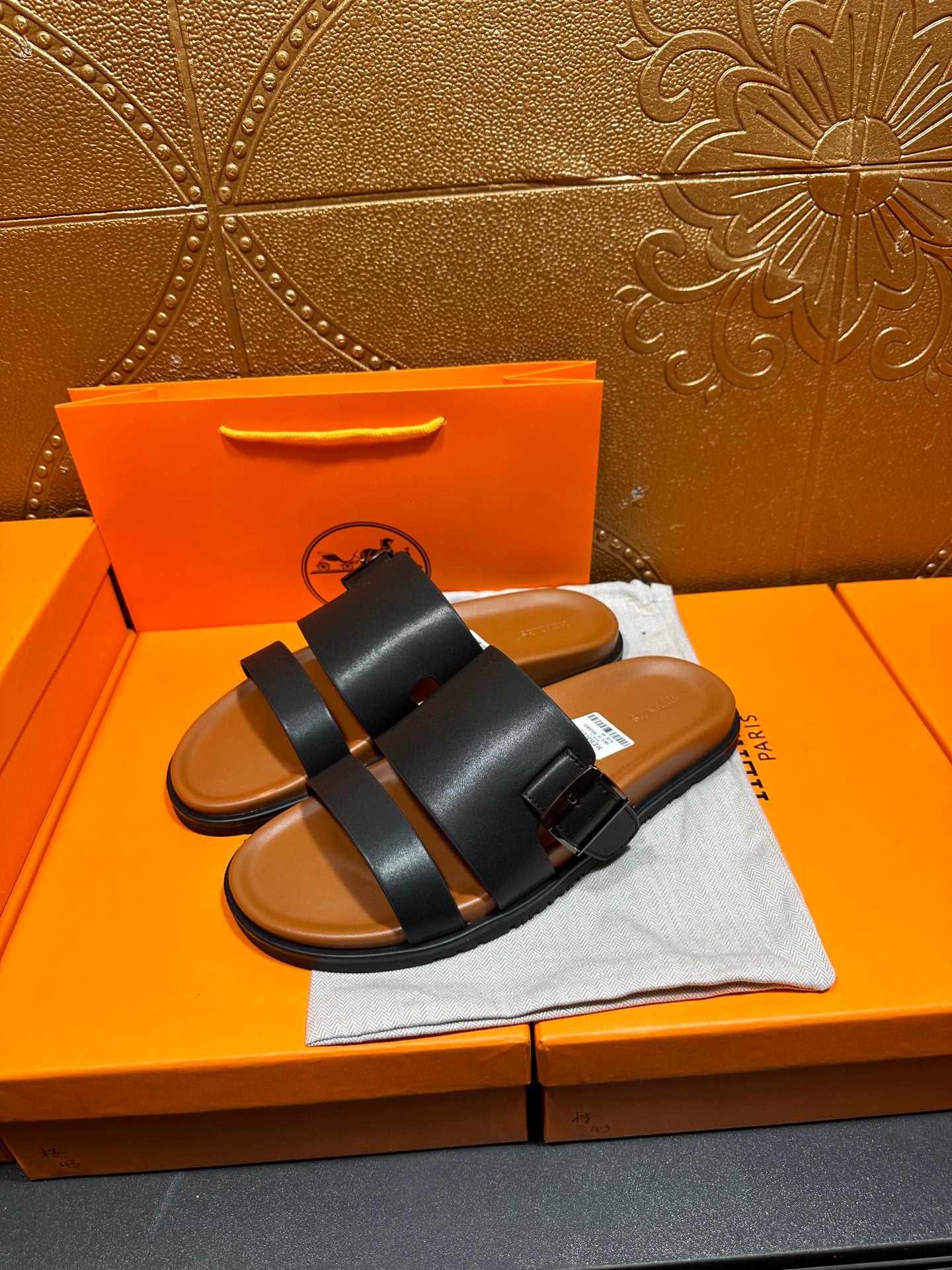 Hermes leather slide sandals in black with wide straps and single buckle strap