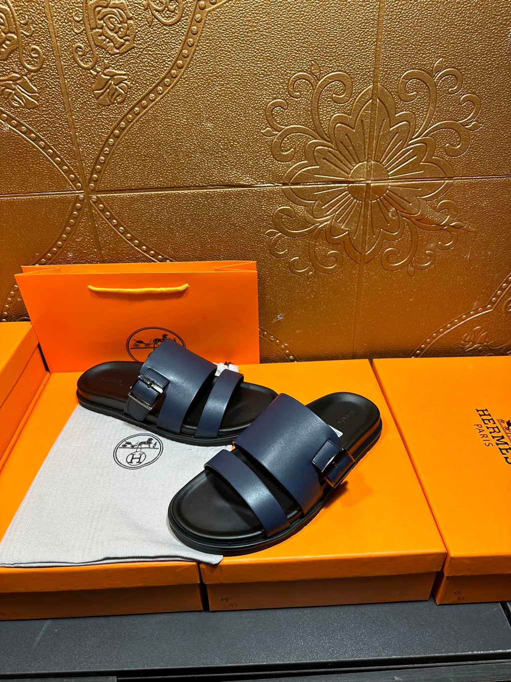 Hermes dark blue sandals with two straps over the foot and buckle closure.