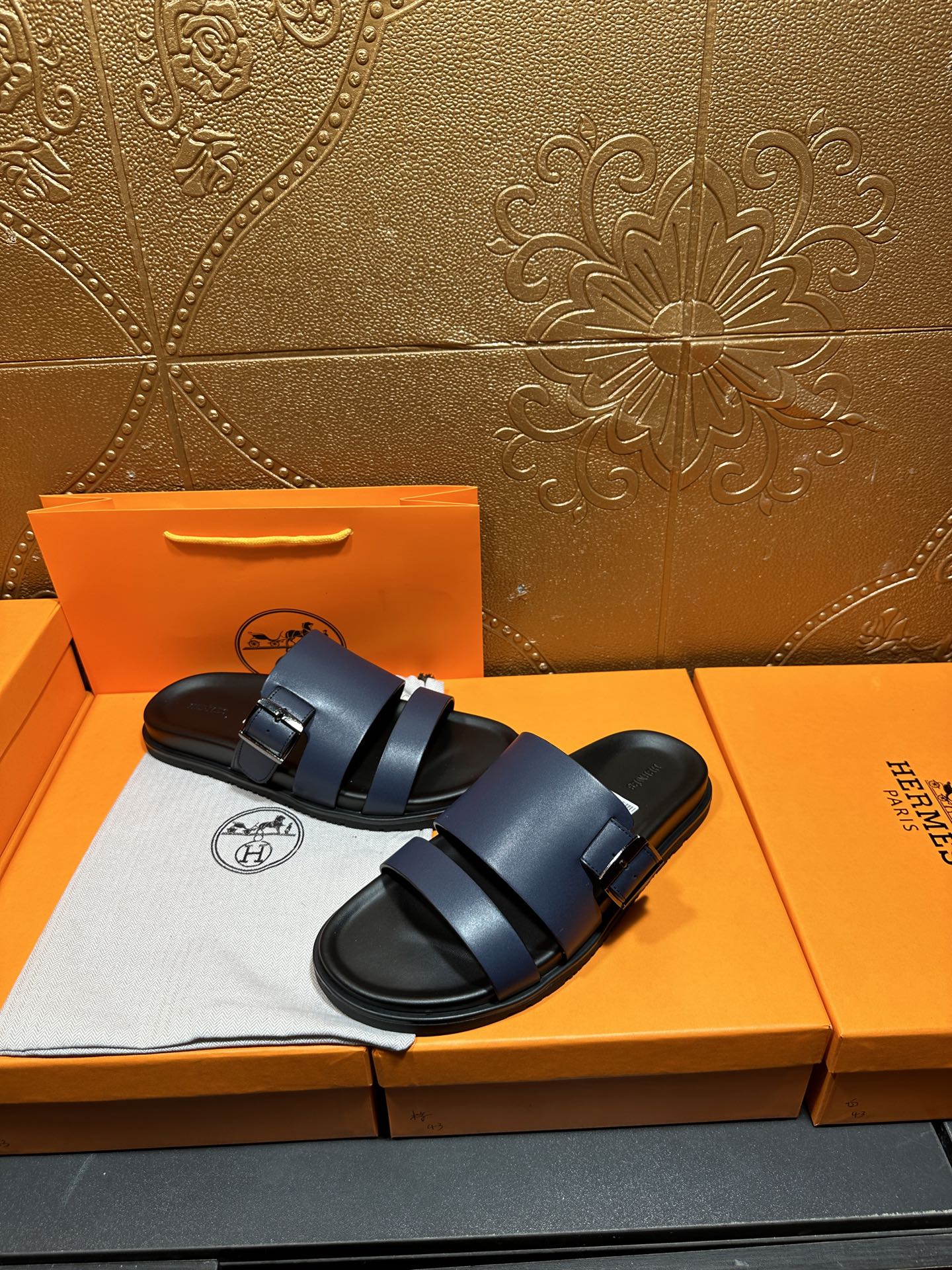 Hermes dark blue sandals with two straps over the foot and buckle closure.