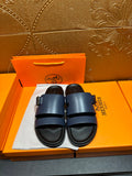 Hermes leather sandals in dark blue with two adjustable straps and black sole.