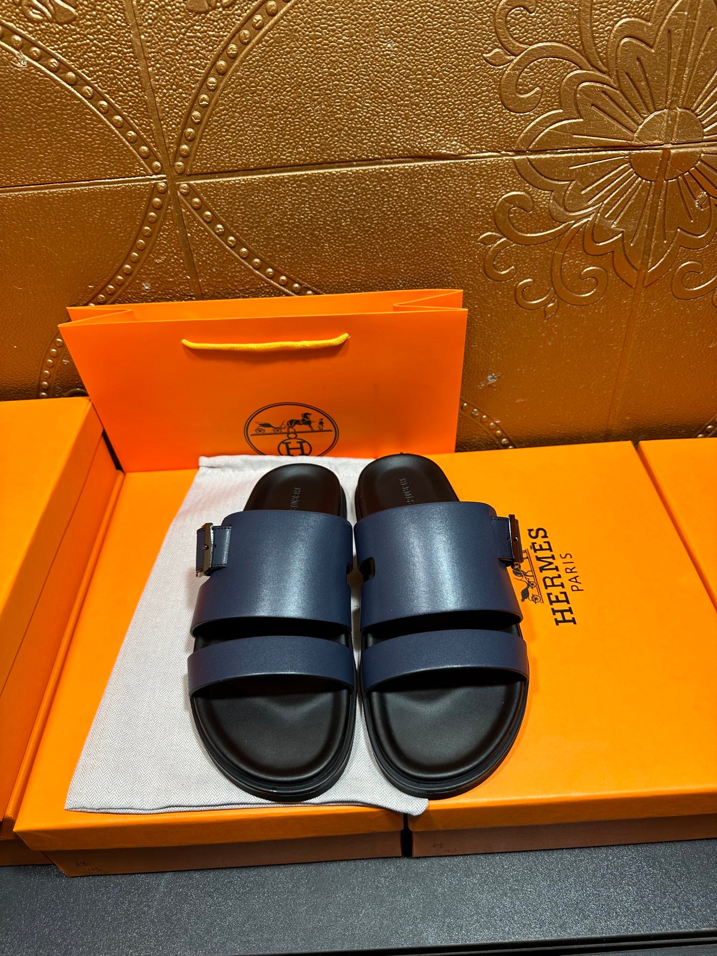 Hermes leather sandals in dark blue with two adjustable straps and black sole.