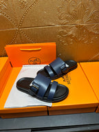 Hermes dark blue sandals with adjustable buckle straps and black rubber sole.