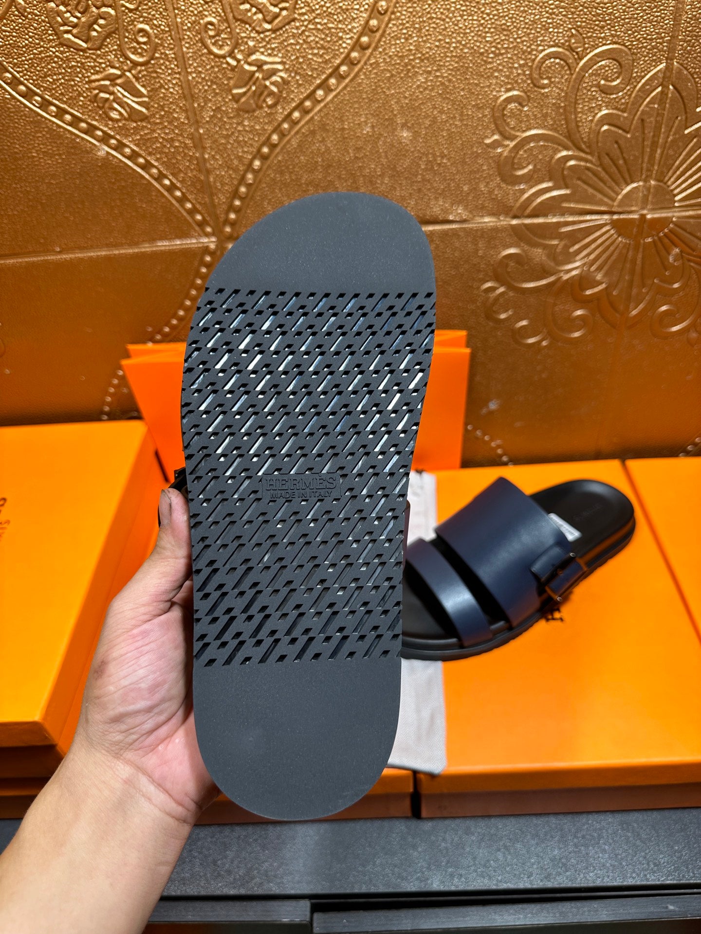 Hermes sandals outsole view in dark blue with textured tread pattern.