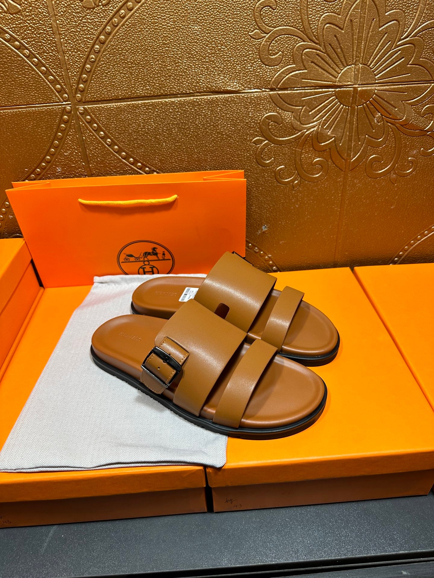 Tan leather slide sandals with double straps and buckle detail, front top view