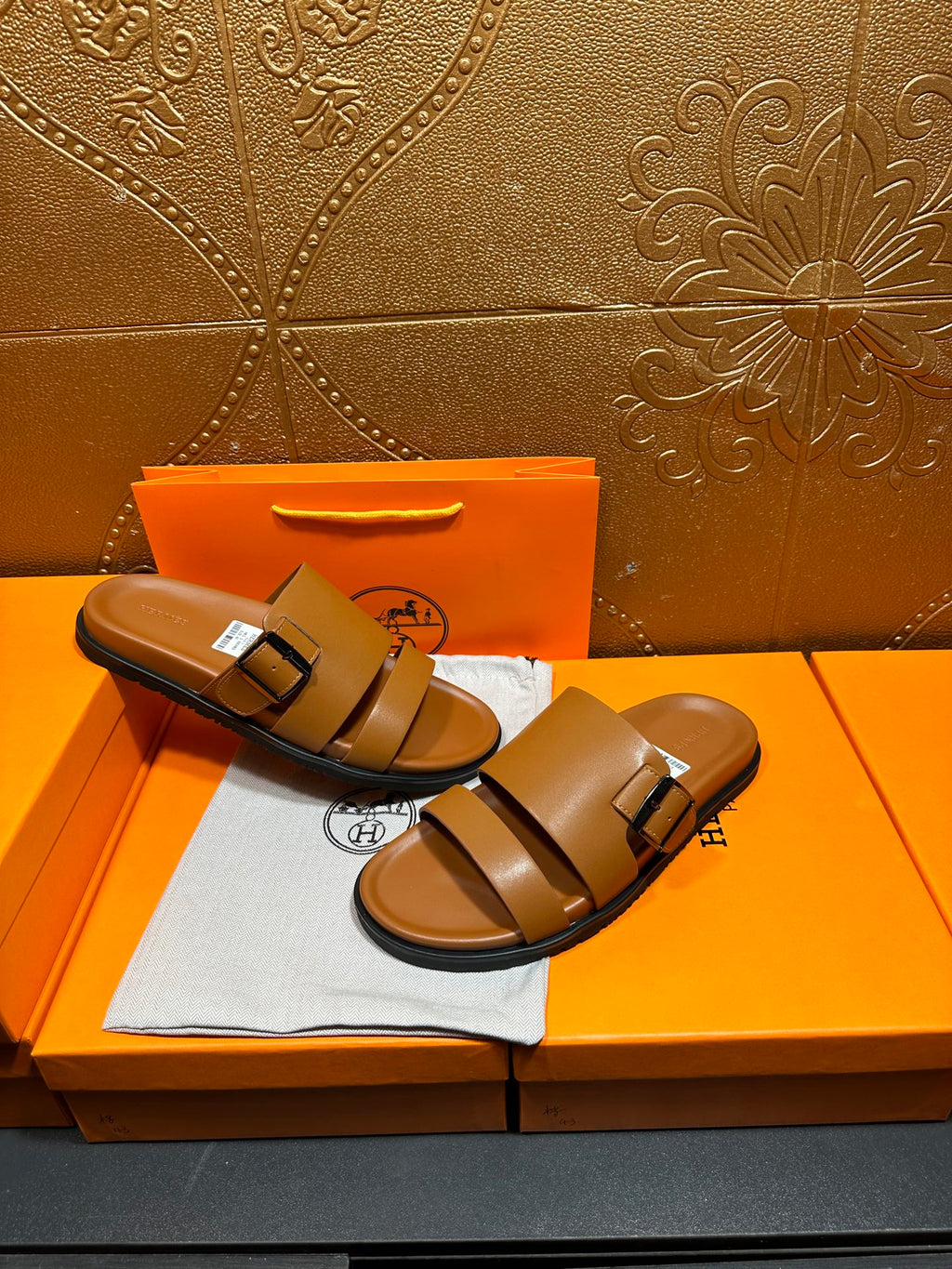 Tan leather slide sandals with two buckle straps, front view