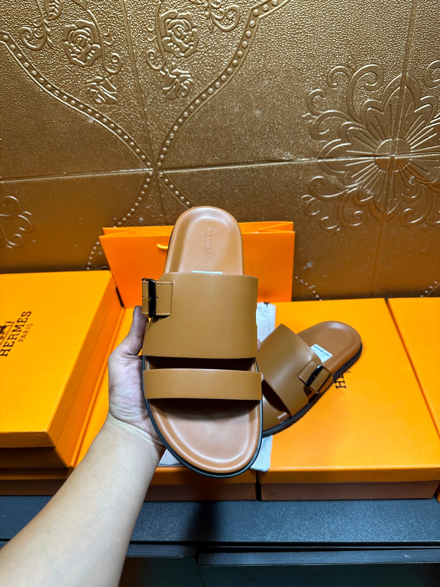 Tan leather slide sandals held up, two buckle straps and cushioned sole