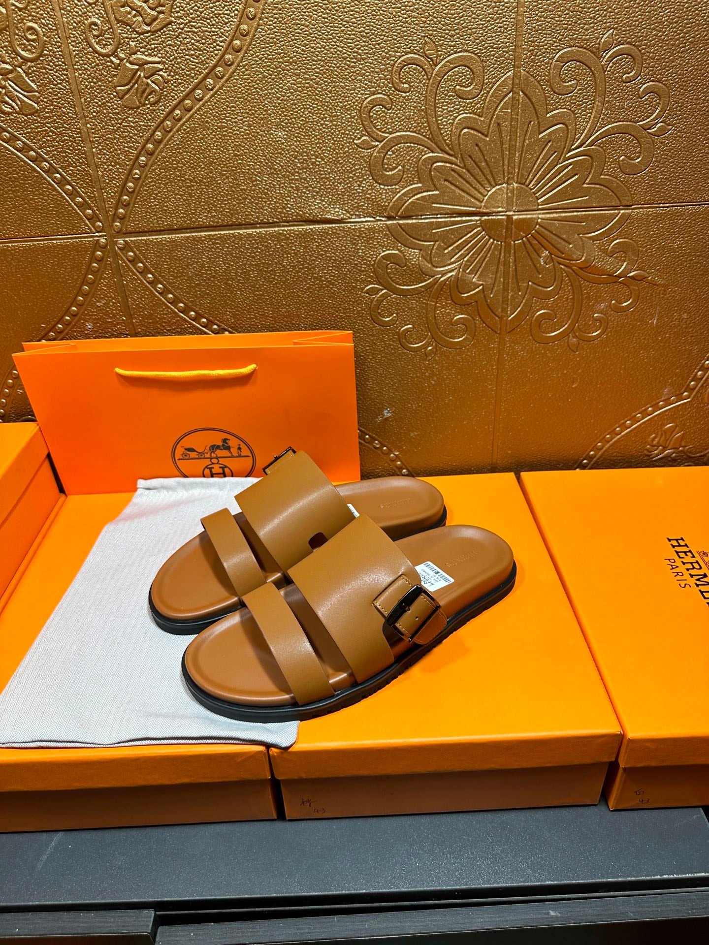 Tan leather slide sandals with two buckle straps, side-by-side pair view