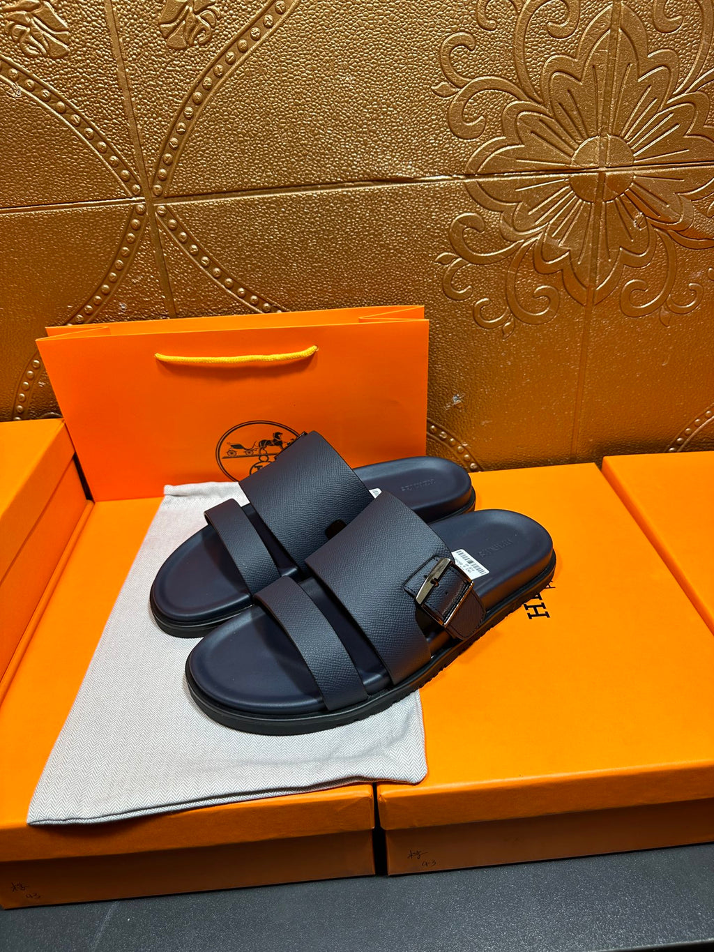 Blue slide sandals with double buckled straps, angled view on display