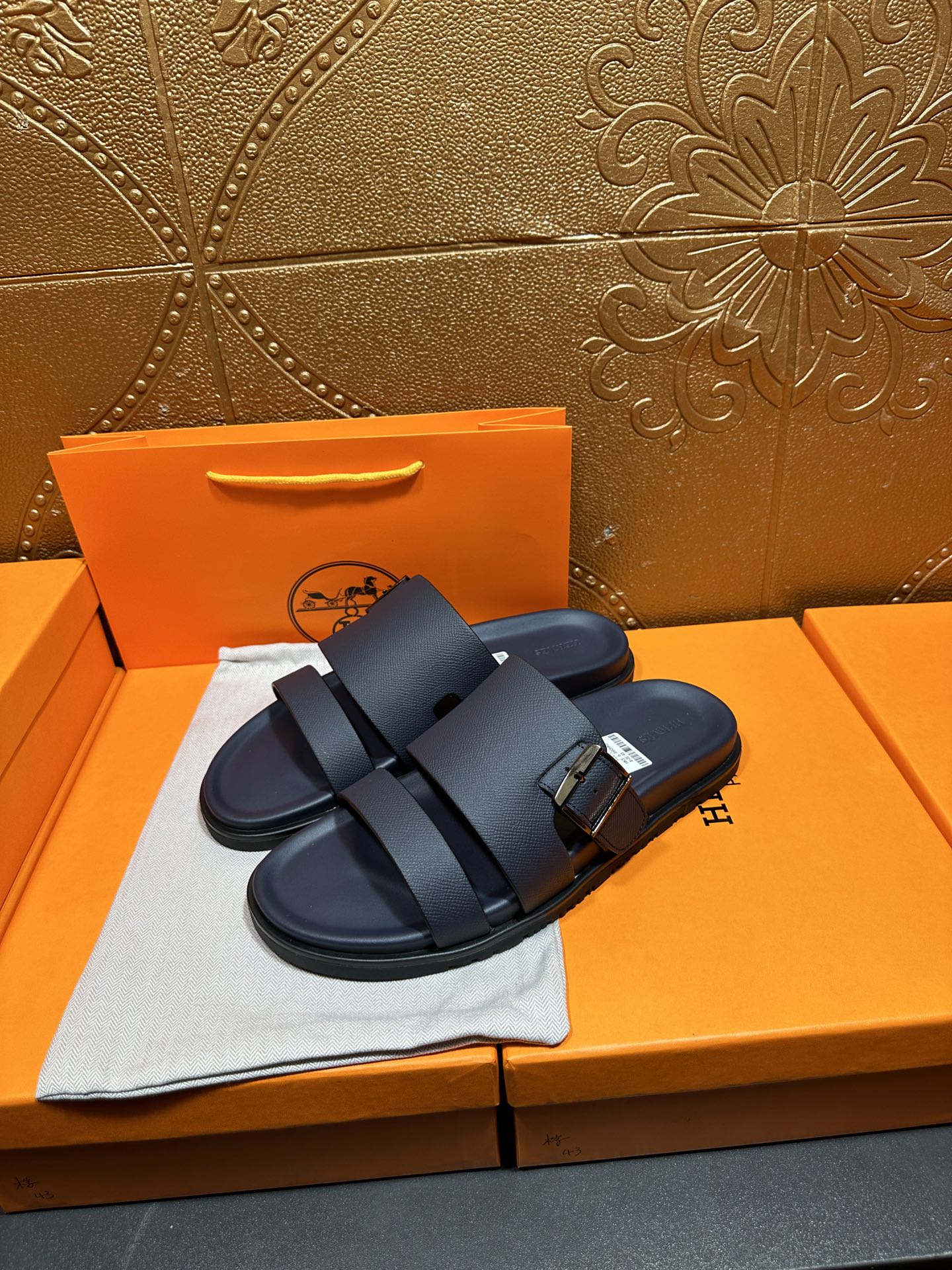 Blue slide sandals with double buckled straps, angled view on display