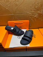 Blue slide sandals with two buckled straps, one sandal shifted slightly