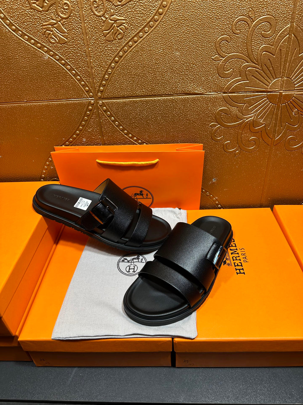 Hermes black slide sandals with double straps, top view on shoebox