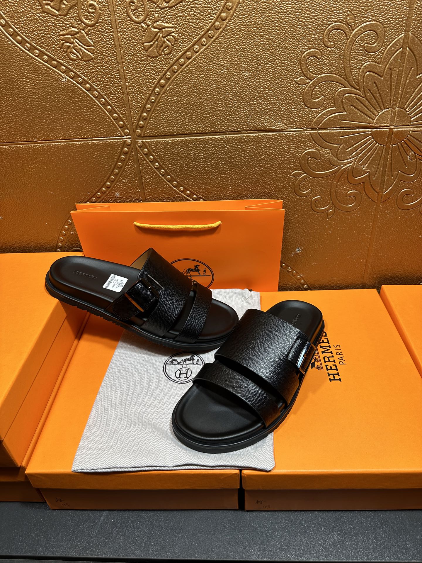 Hermes black slide sandals with double straps, top view on shoebox