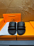 Hermes black leather slide sandals with double straps, shown on shoebox
