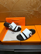 White slide sandals with black footbed and two wide straps