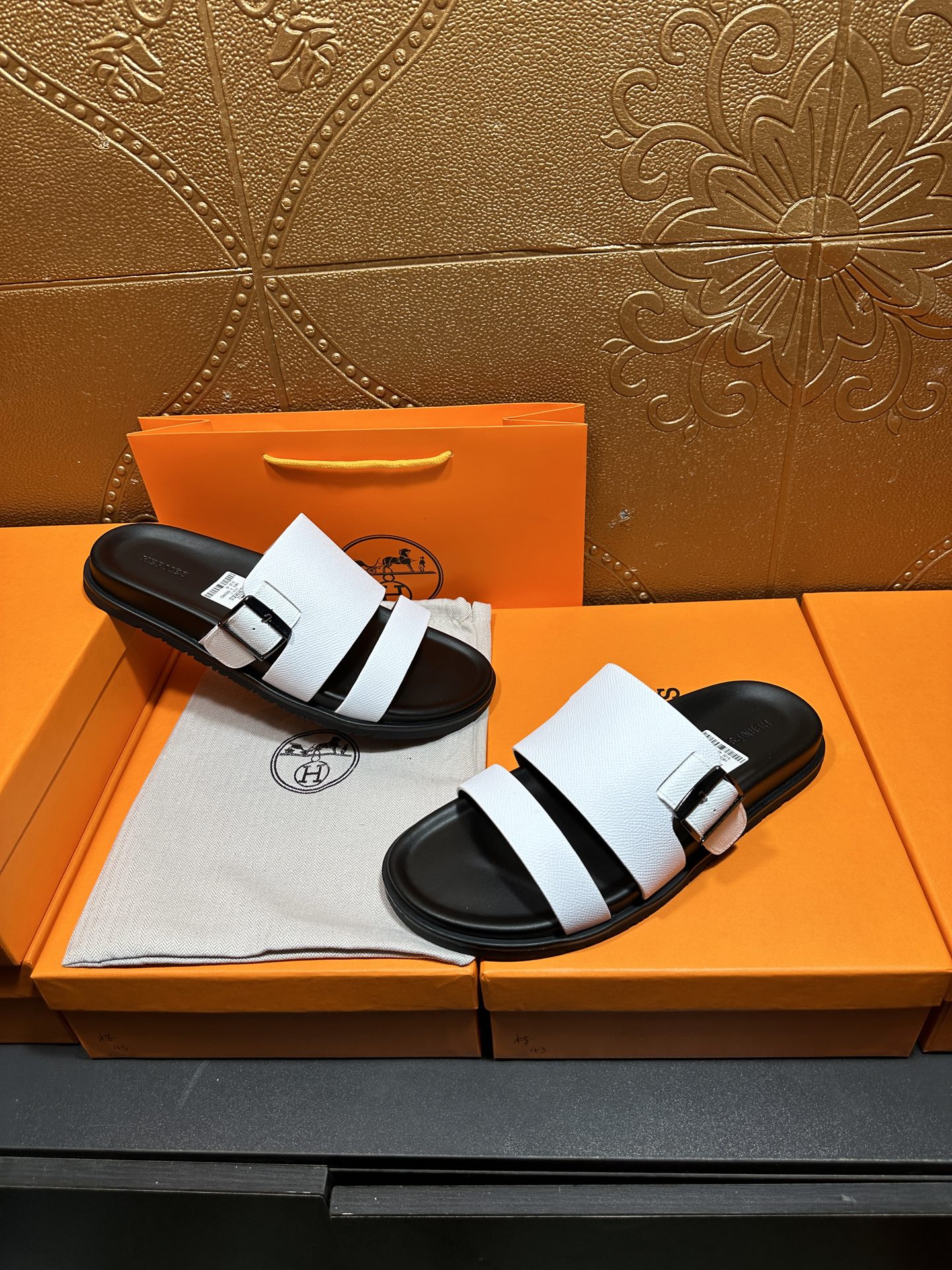 White slide sandals with black footbed and two wide straps