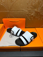 White leather slide sandals on black platform sole with strap detail