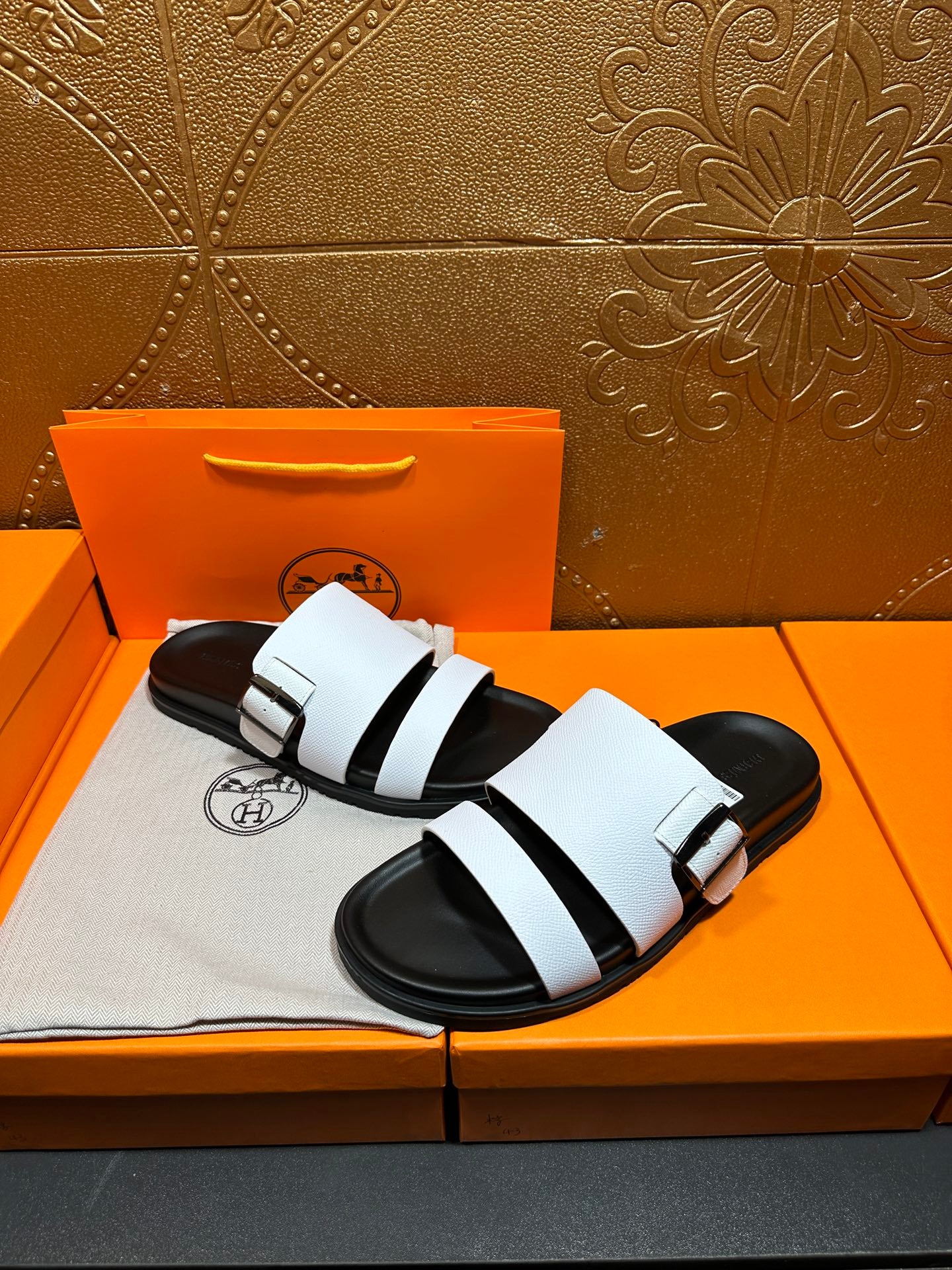 White leather slide sandals on black platform sole with strap detail