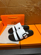 White leather slide sandals with two straps and black sole