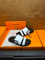 Pair of white-and-black slide sandals with adjustable buckle straps