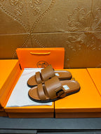 Hermes tan-brown slide sandals with two wide straps and adjustable buckle